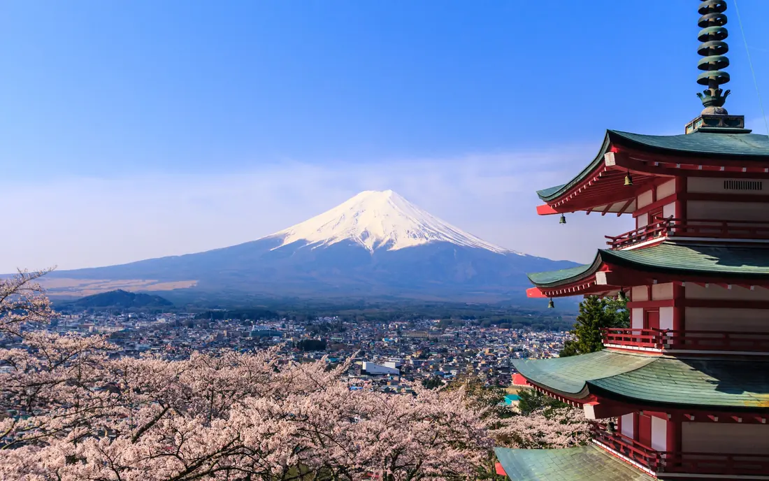 The Chureito Pagoda above Fujiyoshida, with Mount Fuji behind and cherry blossom in front